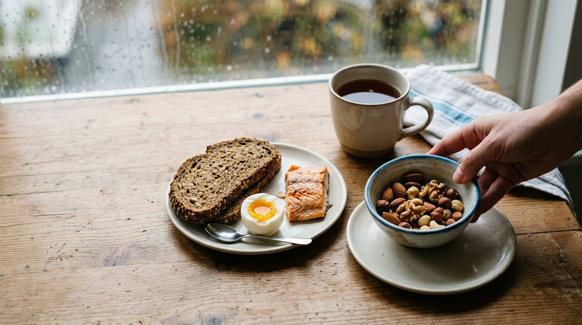 Ontbijttafel met noten, volkorenbrood, ei en zalm als natuurlijke bronnen van sporenelementen.